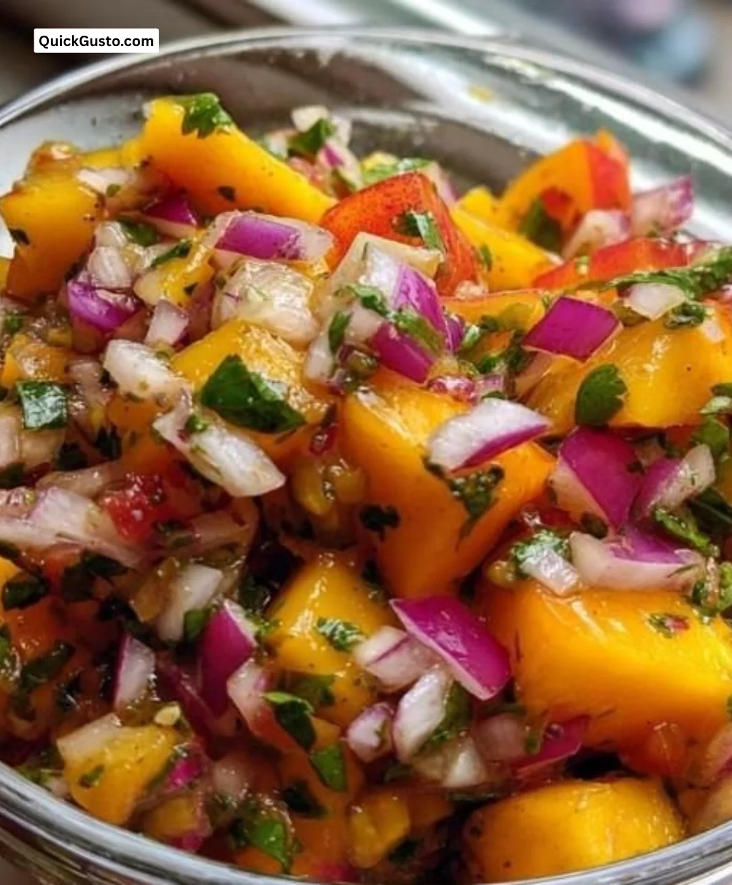 Delicious Peach Mango Salsa in a bowl garnished with fresh herbs