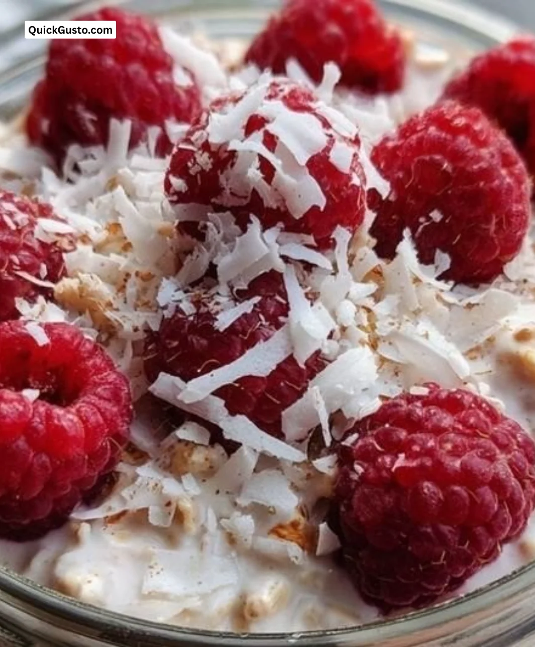 Bowl of Raspberry Coconut Overnight Oats topped with fresh raspberries and coconut flakes.