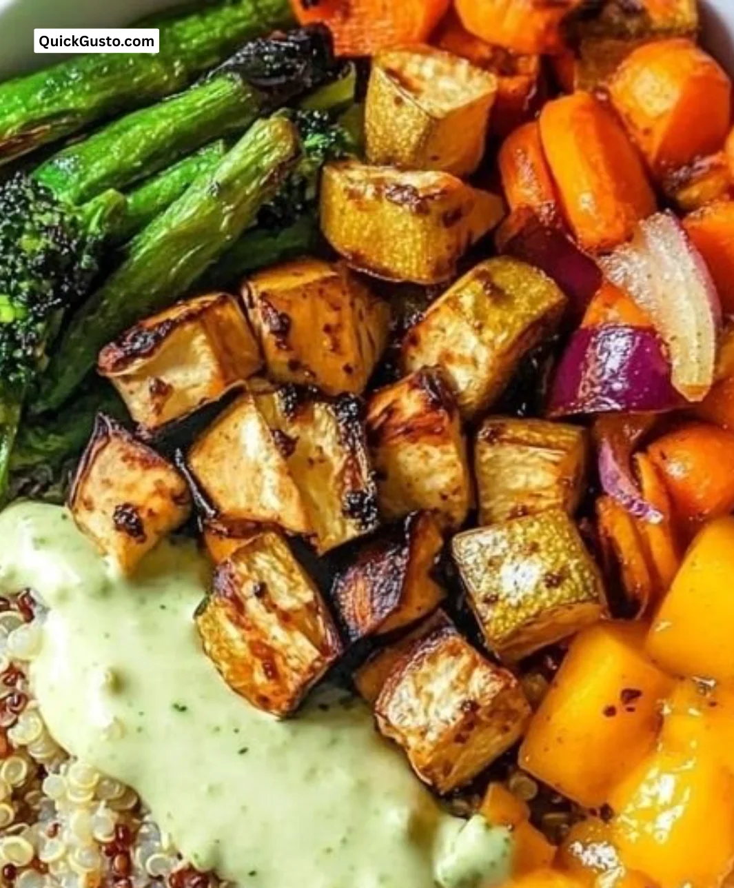Roasted veggie quinoa bowl topped with colorful vegetables and herbs.