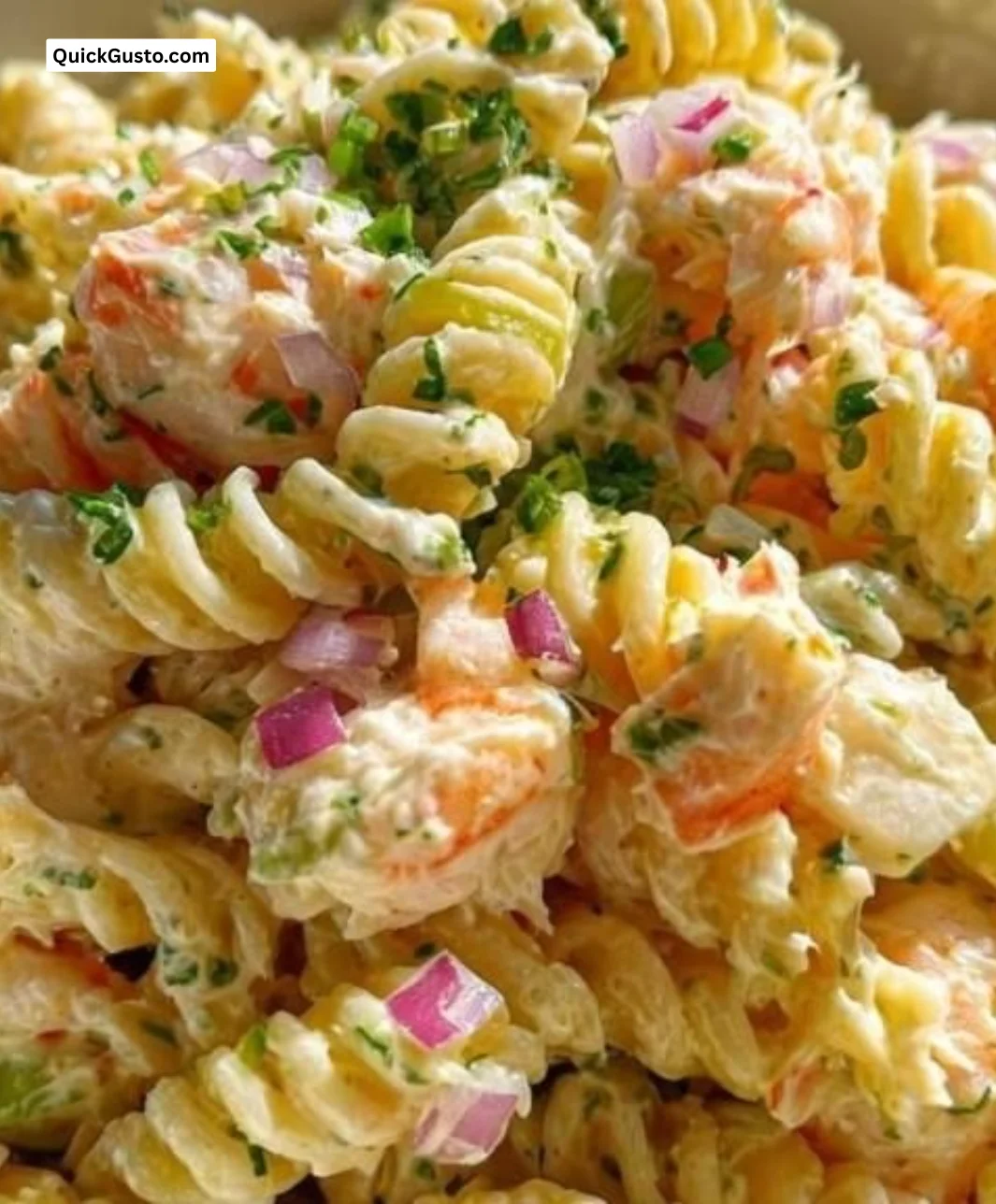 Delicious seafood pasta salad featuring crab and shrimp garnished with herbs.
