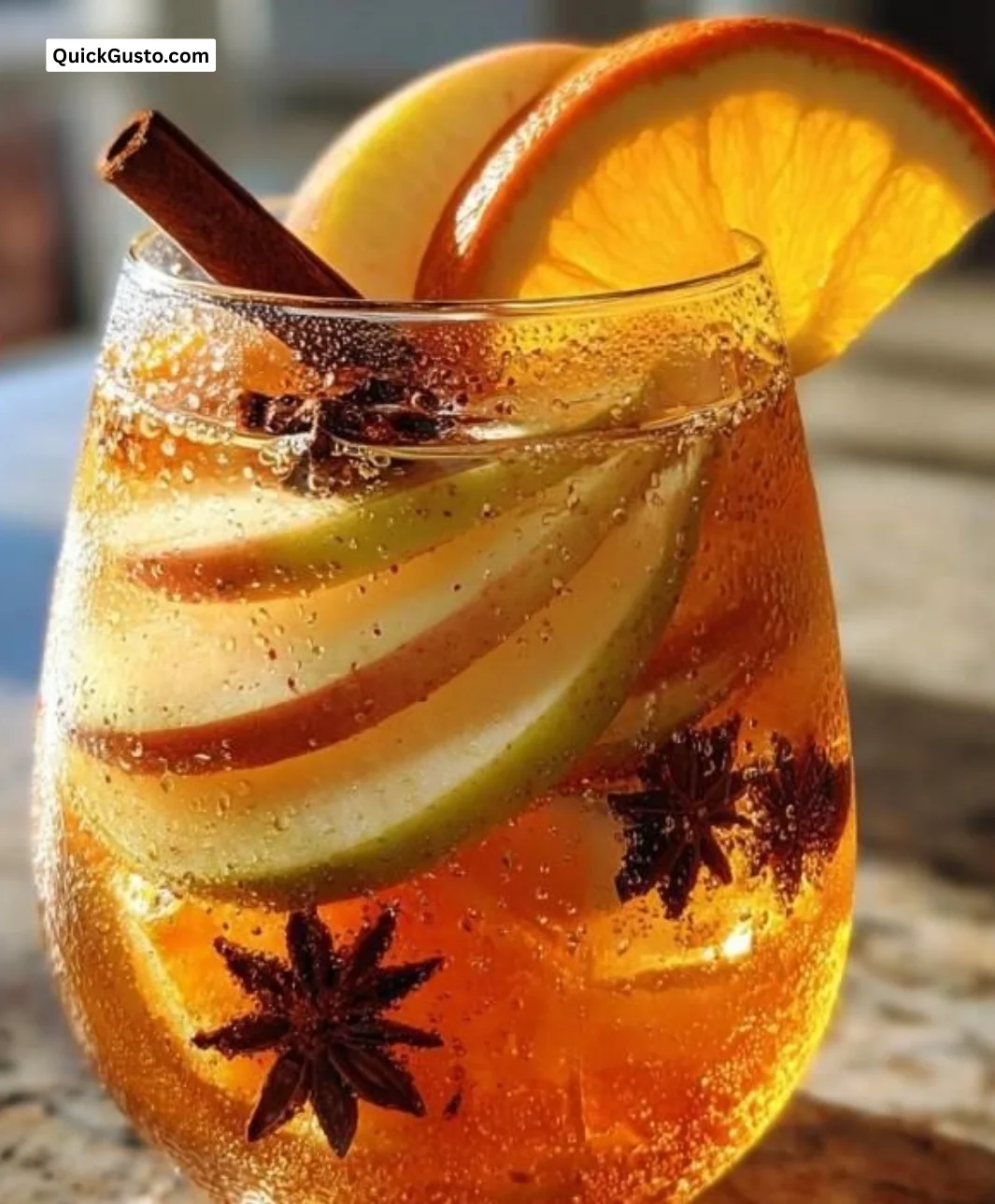 Spiced Apple Cider Sangria in a glass with cinnamon sticks and apple slices