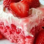 Slice of Strawberry Jello Poke Cake on a white plate with fresh strawberries