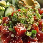 A colorful Tuna Poke Bowl topped with fresh vegetables and sesame seeds.