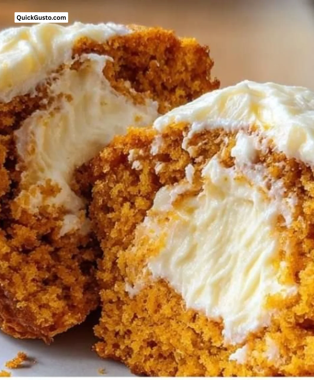 Bakery-style pumpkin muffins with cream cheese swirl on a wooden table