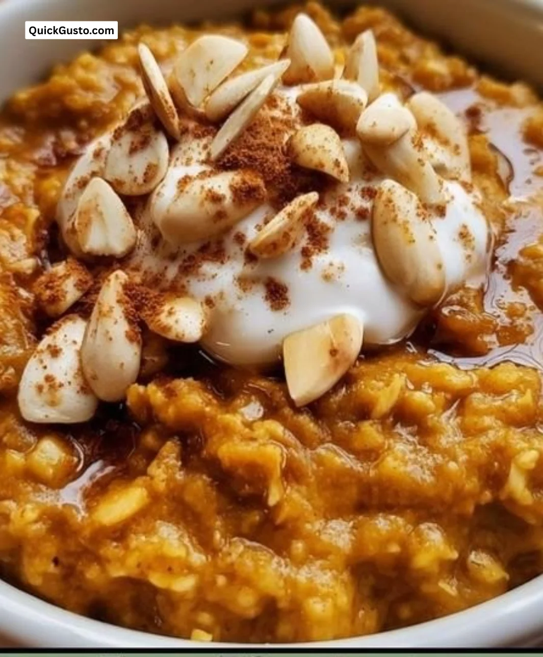 Bowl of warm spiced pumpkin oatmeal topped with nuts and spices