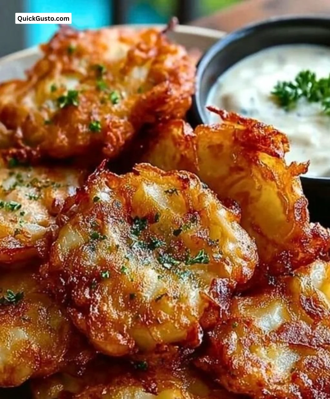 Crispy Amish onion fritters served on a plate with dipping sauce