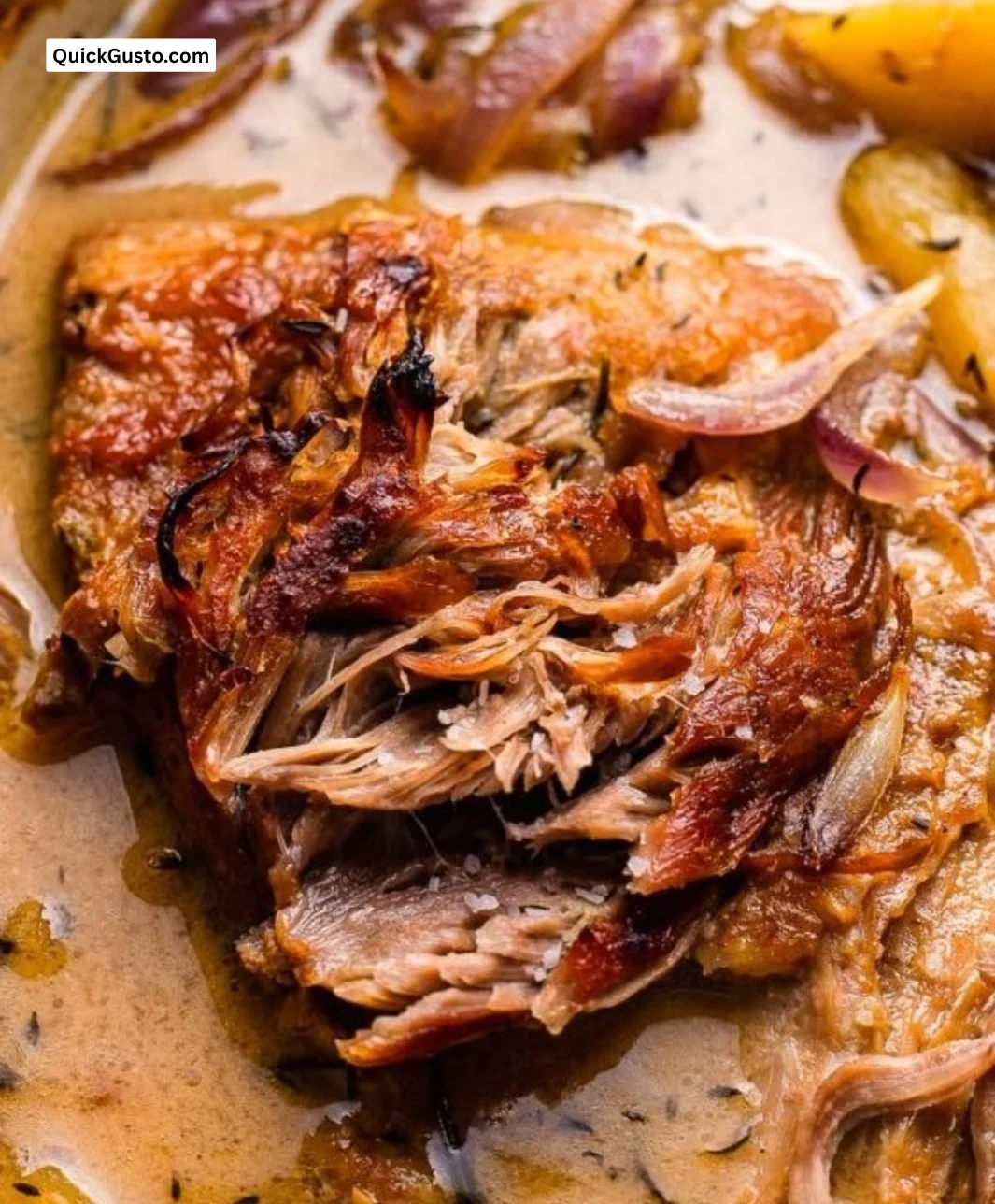 Apple cider braised pork shoulder served with vegetables on a plate