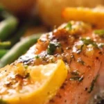 Perfectly baked salmon on a plate with herbs and lemon garnish