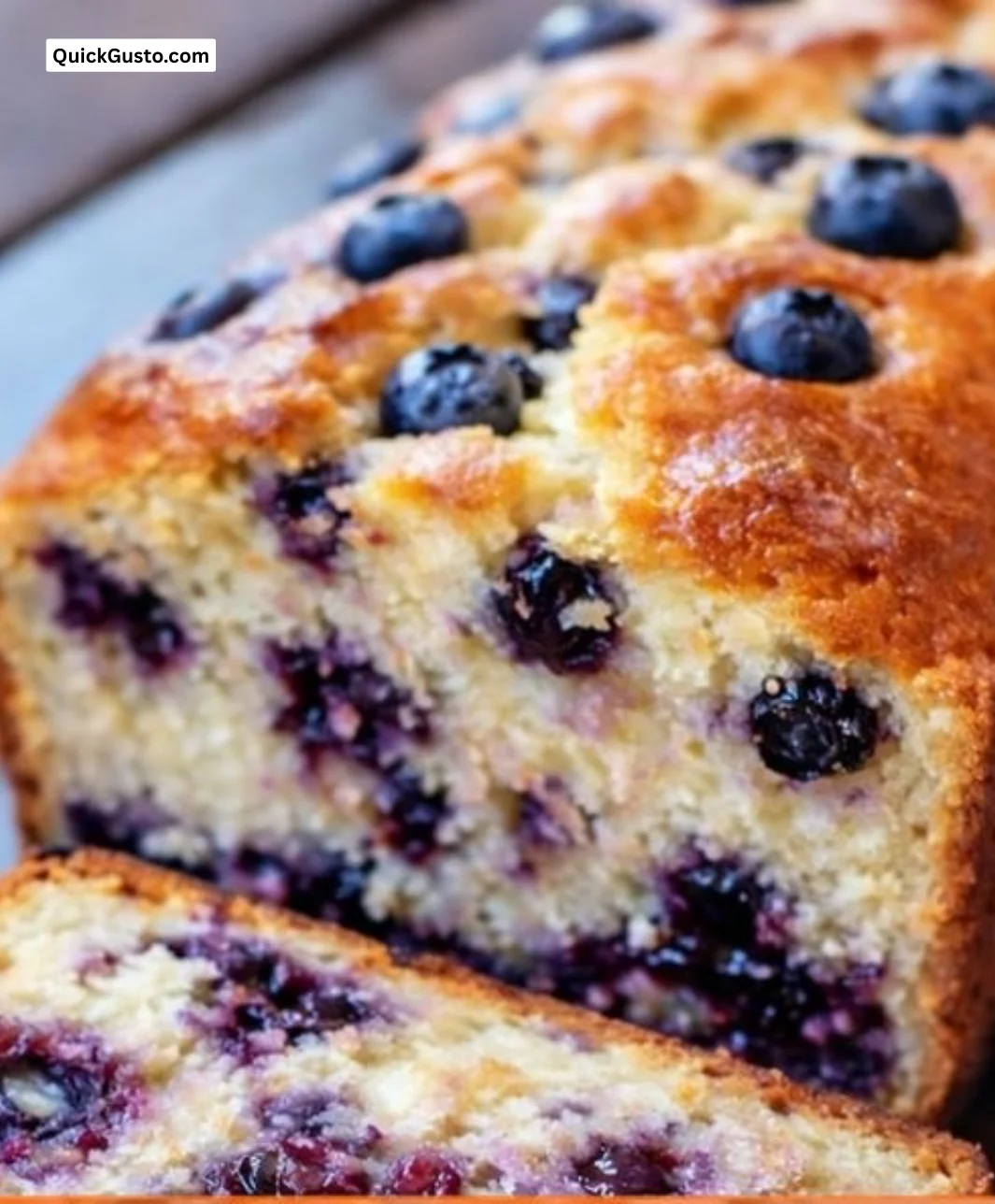 Loaf of freshly baked blueberry bread with vibrant blueberries on top.