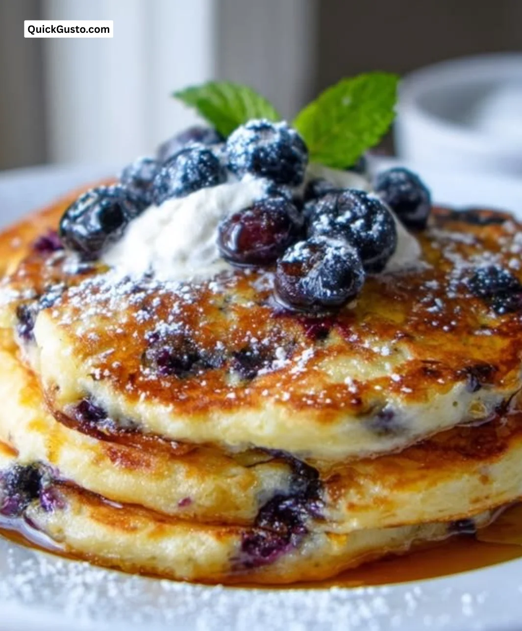 Fluffy blueberry ricotta pancakes topped with fresh blueberries and syrup