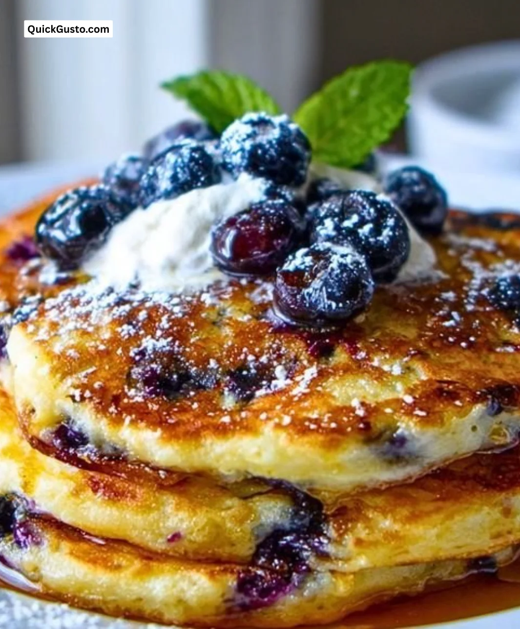 Fluffy blueberry ricotta pancakes topped with fresh blueberries and syrup