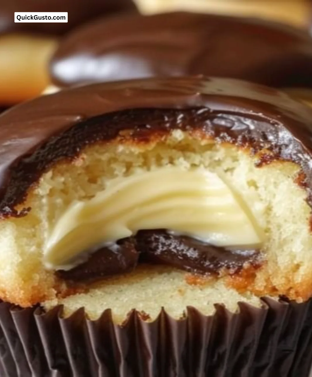Delicious Boston Cream Cupcakes topped with chocolate frosting and vanilla filling.
