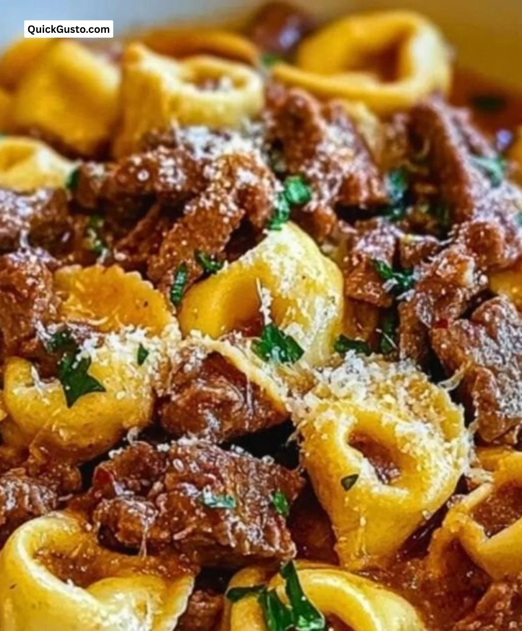 A delicious bowl of cheesesteak tortellini topped with herbs and cheese.