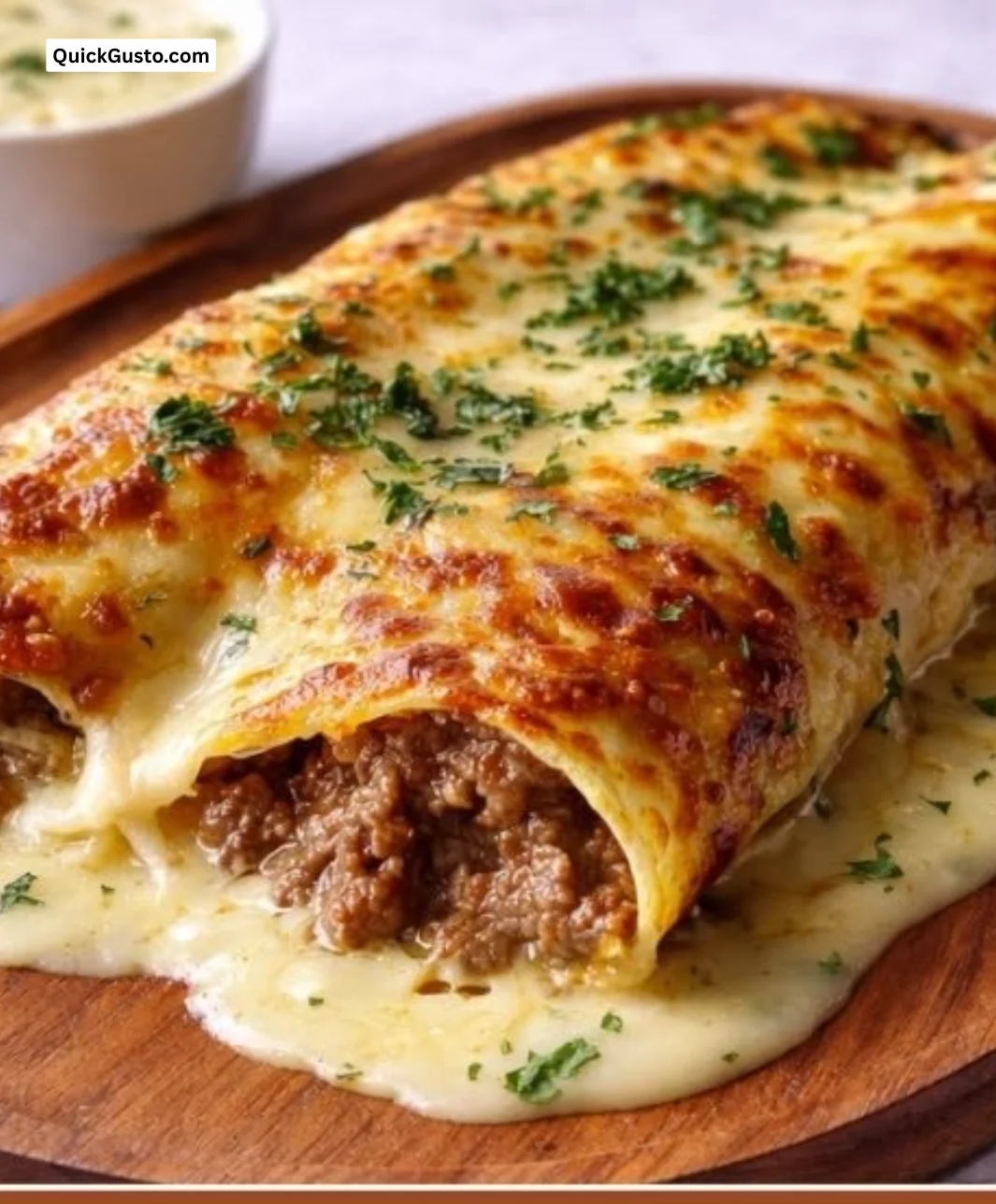 Cheesy chicken enchiladas topped with sauce and cheese, served on a plate.
