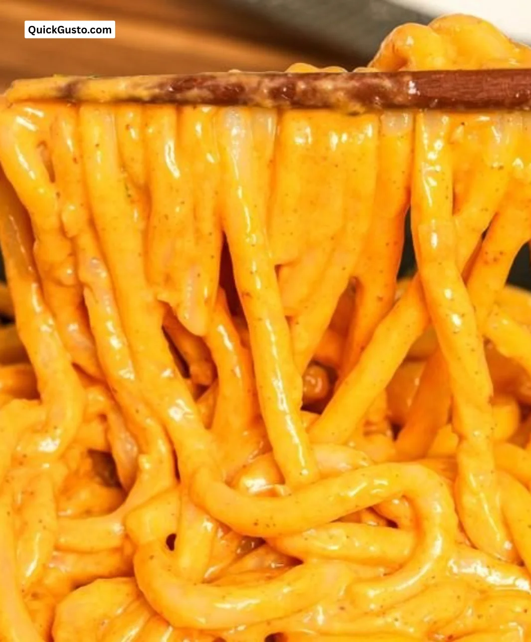 Bowl of creamy gochujang udon noodles topped with colorful vegetables and sesame seeds