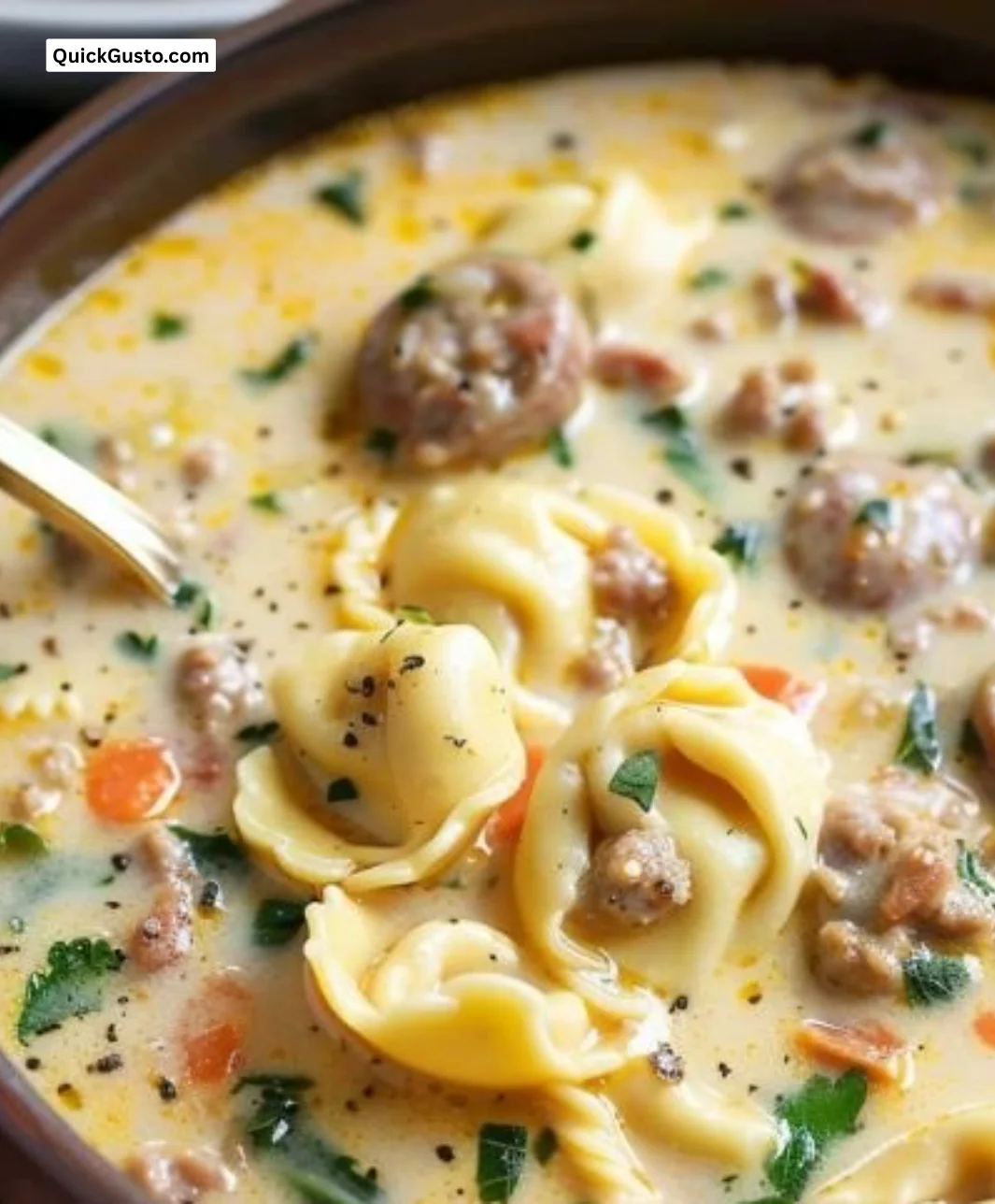 Bowl of creamy sausage tortellini soup topped with herbs