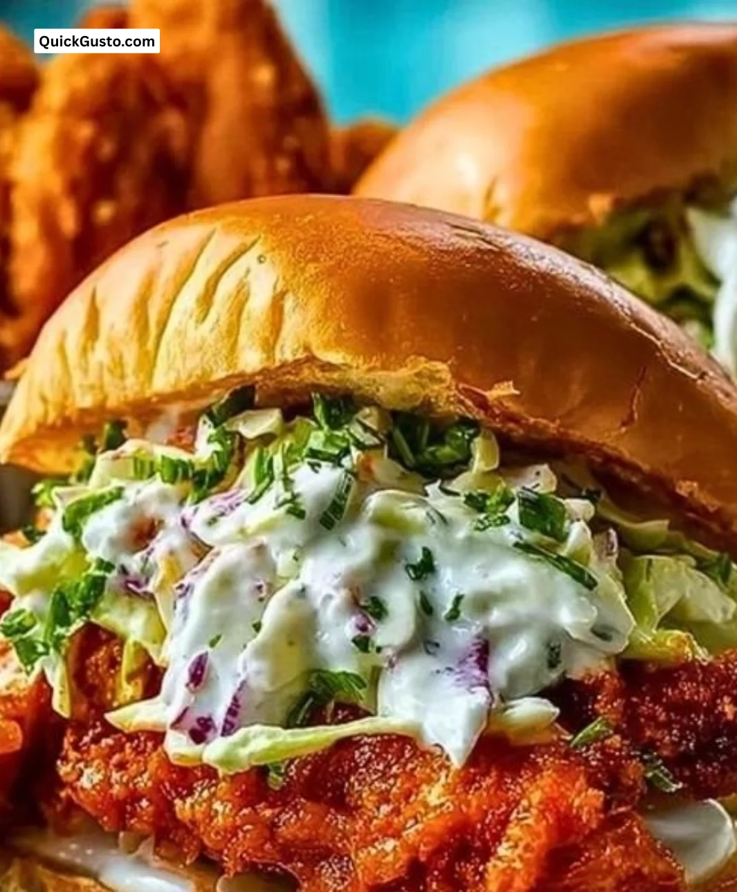 Crispy Buffalo Chicken Sandwich topped with Ranch Slaw on a wooden plate