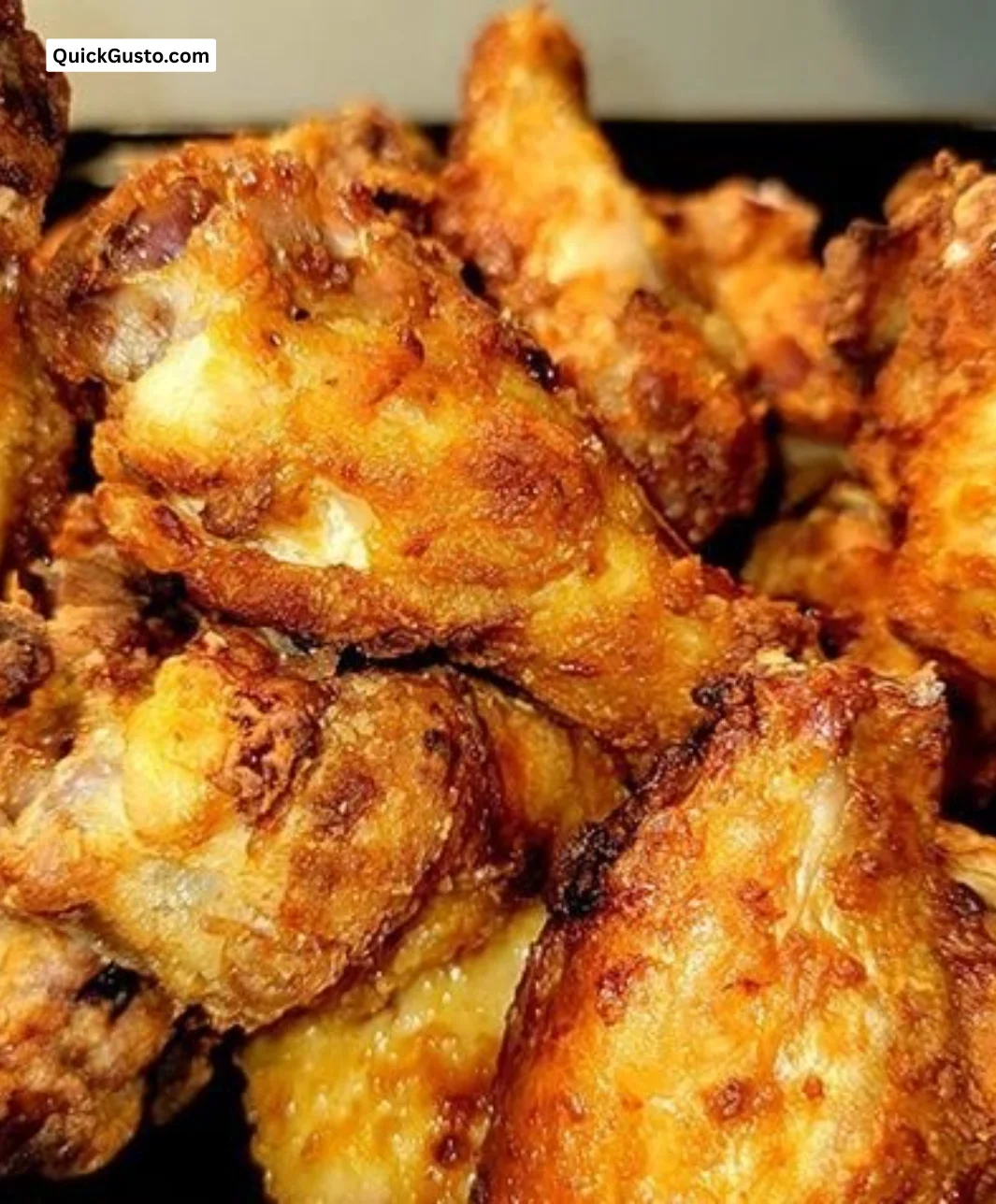 Plate of crispy seasoned chicken wings garnished with herbs