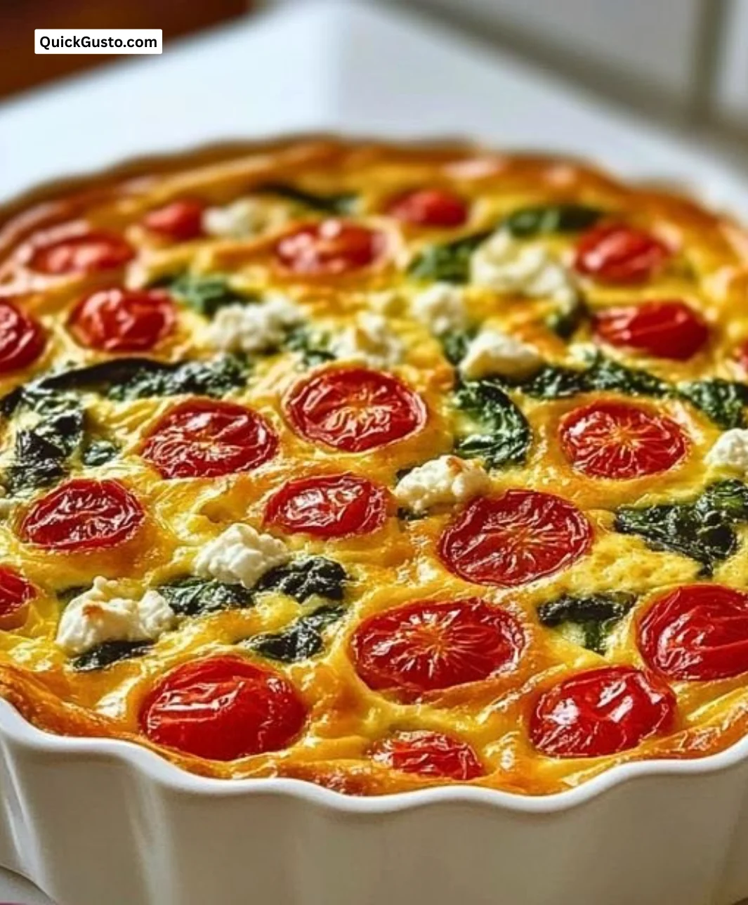 Crustless spinach quiche with tomatoes and feta cheese in a serving dish