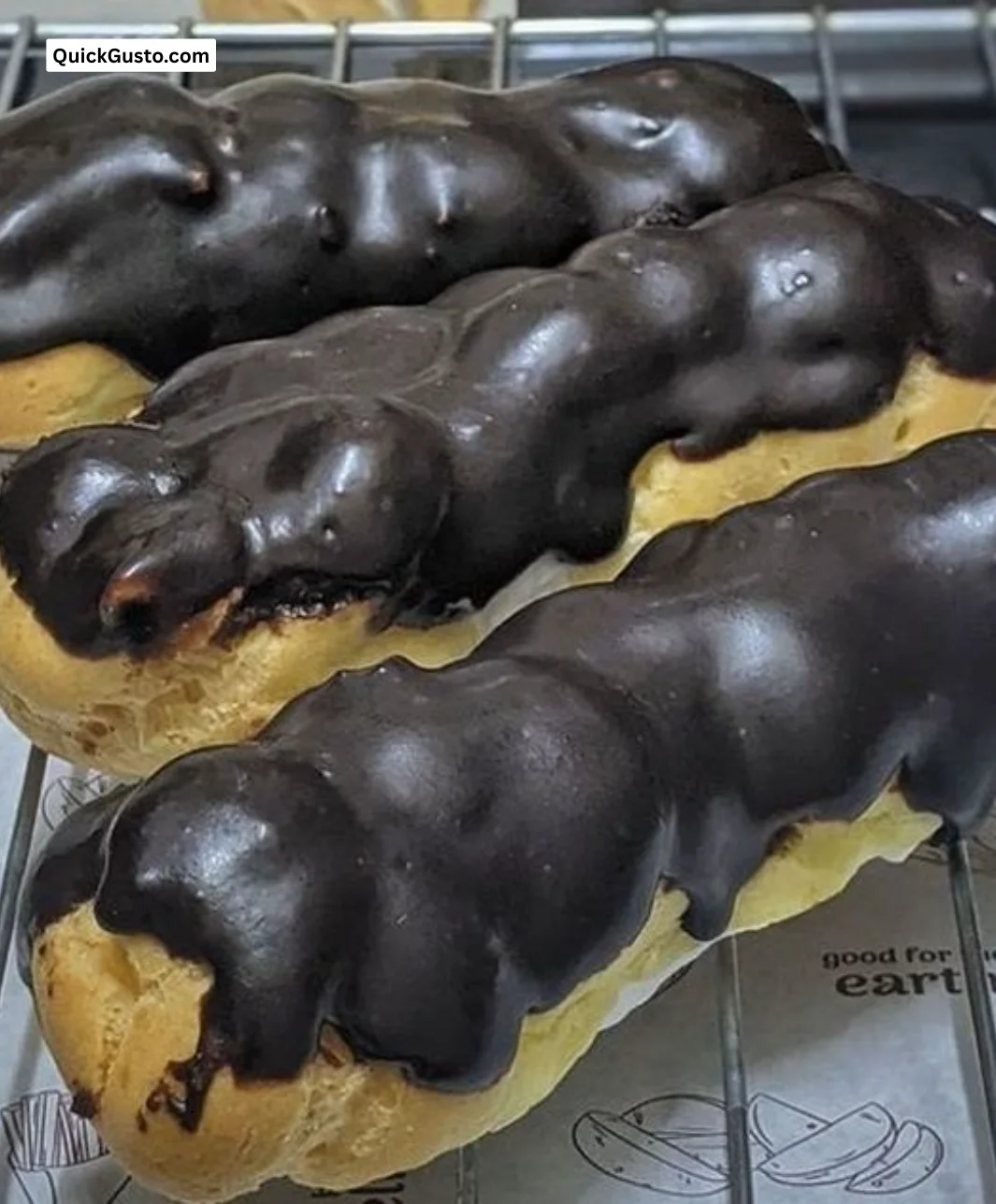 Decadent dark chocolate eclairs on a dessert plate.