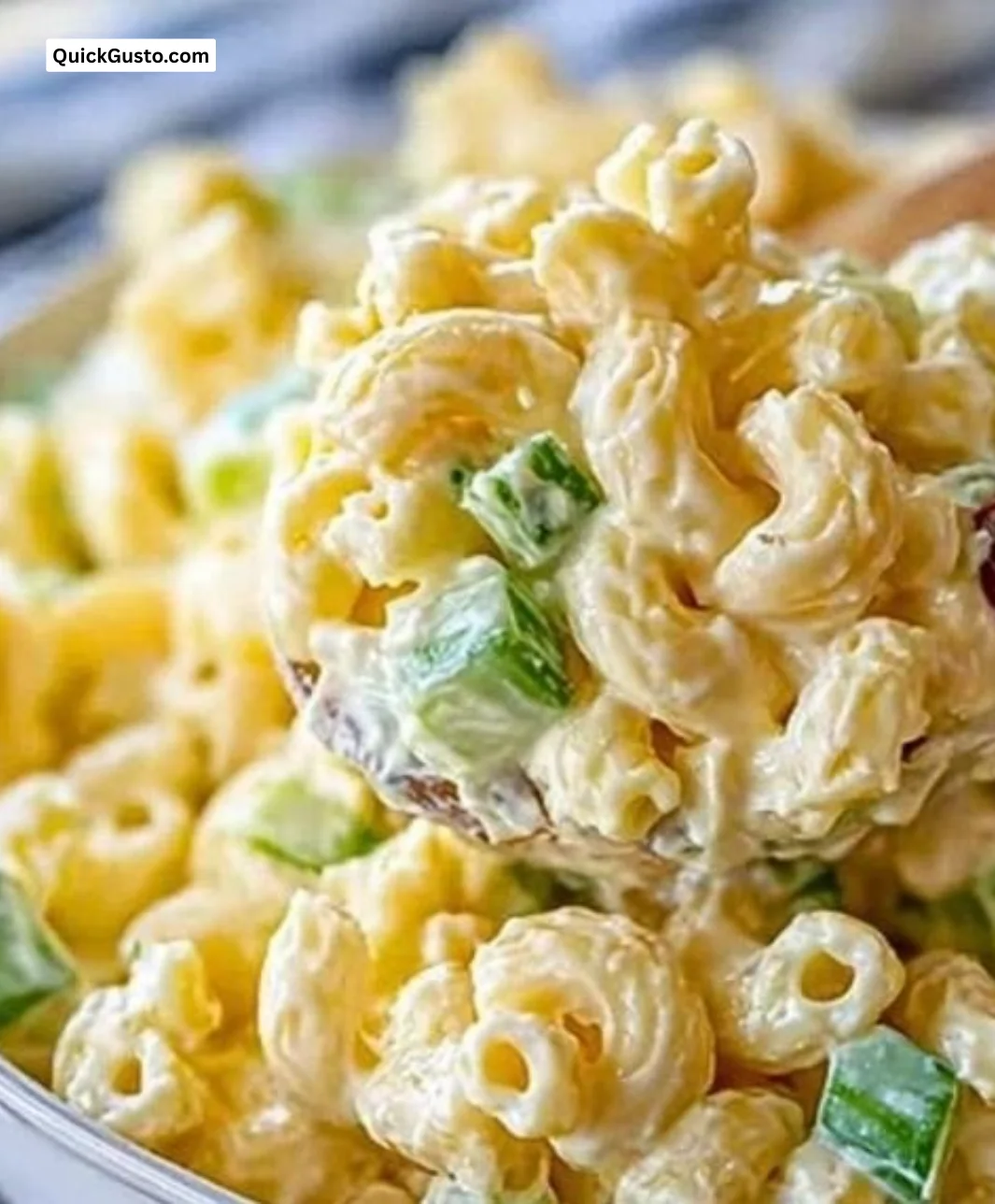 Dolly Parton's creamy macaroni salad served in a bowl with fresh ingredients.