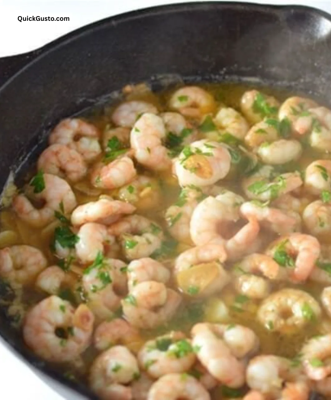 Delicious garlic prawns served on a plate garnished with herbs.