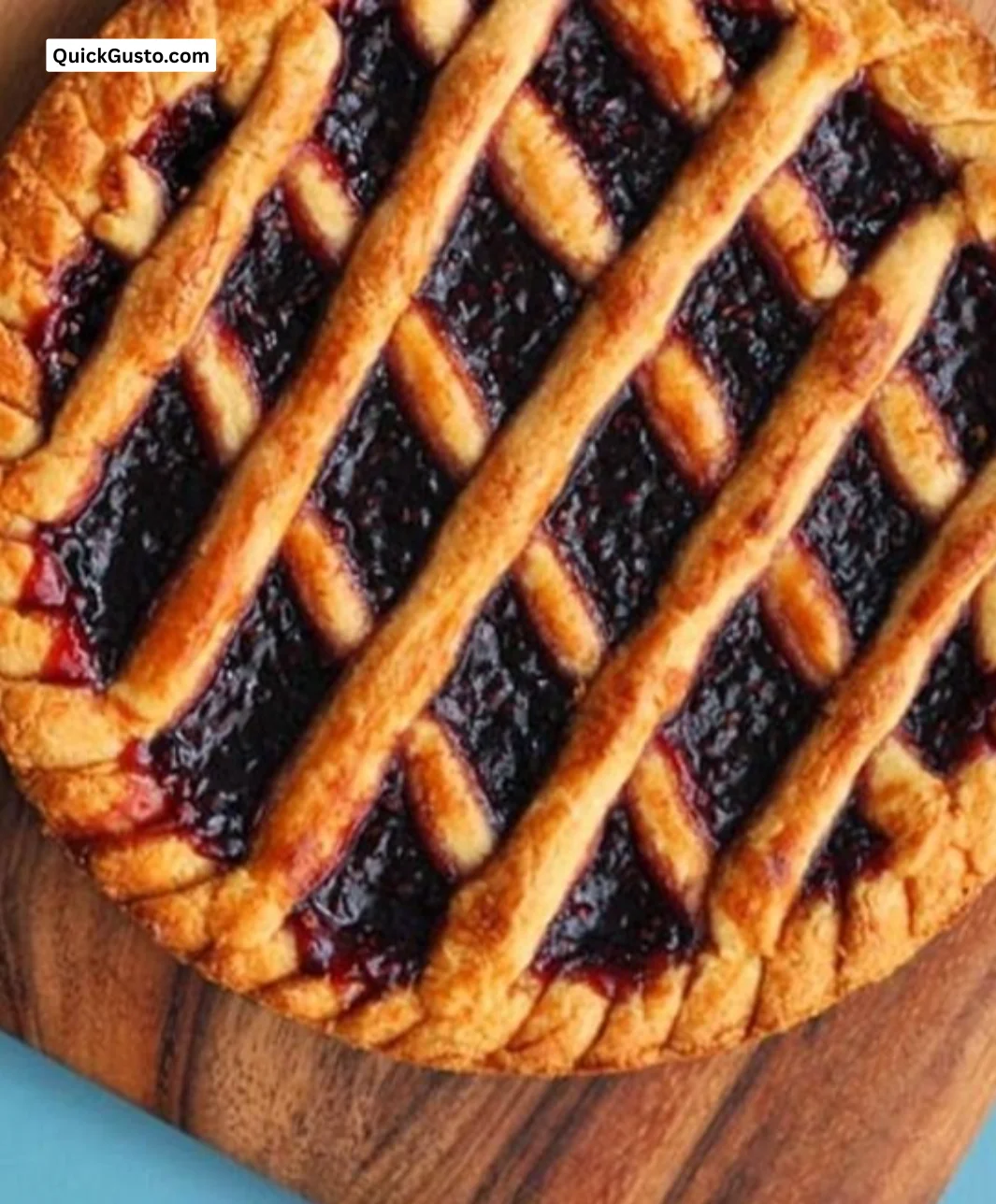 Delicious homemade jam tart with fruit filling on a rustic wooden table.
