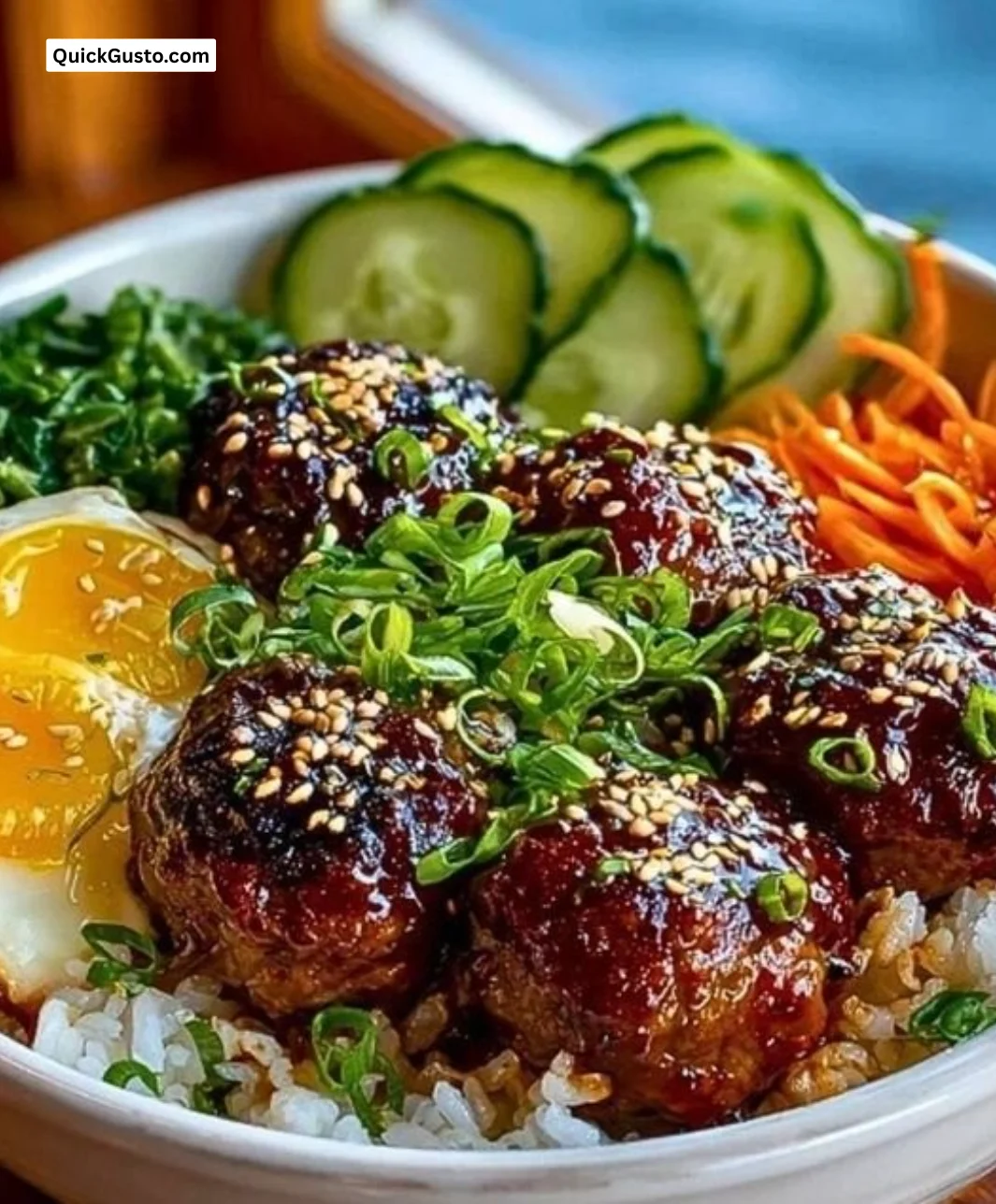 Korean BBQ meatball rice bowl garnished with fresh vegetables and sauces