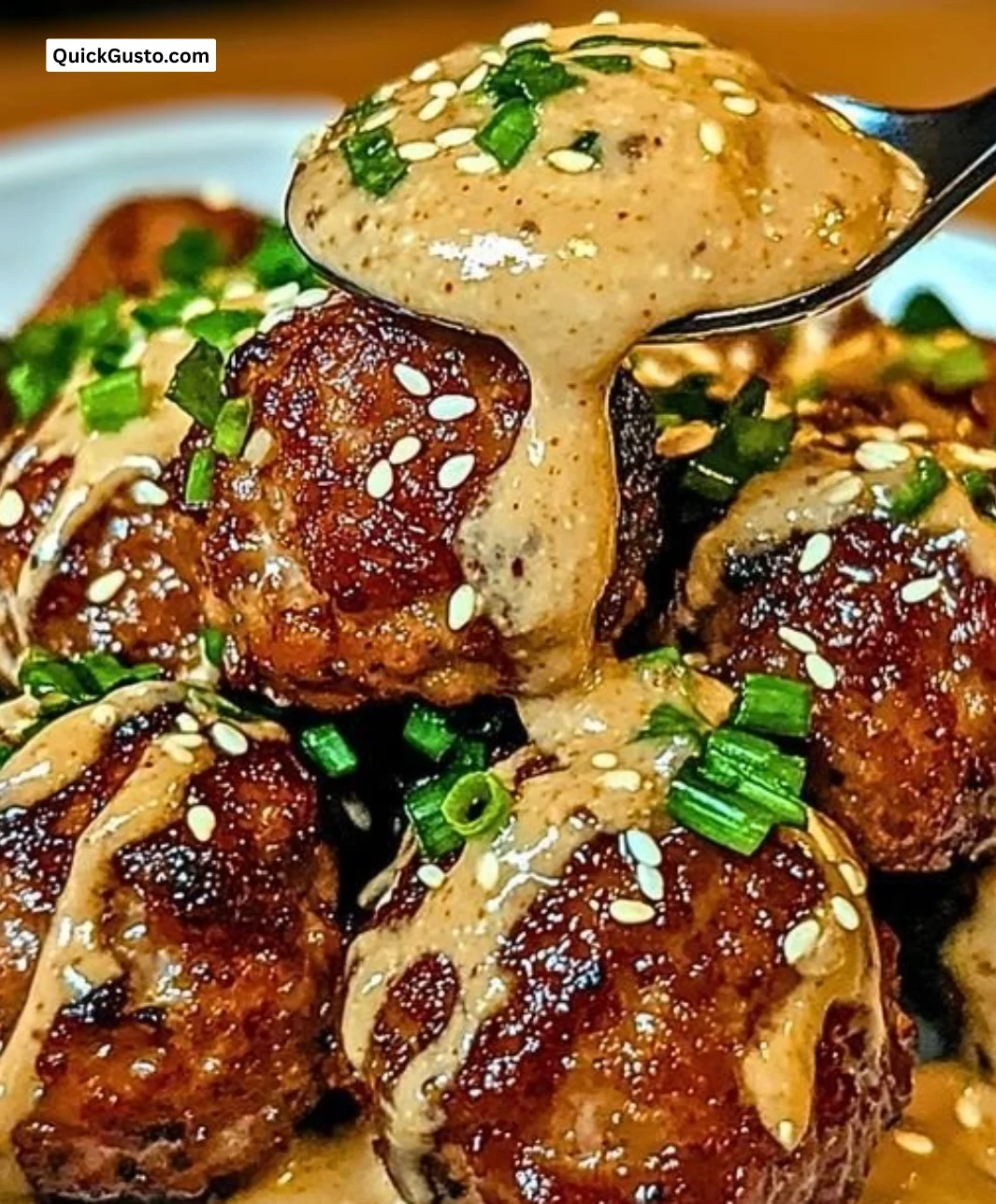 Korean BBQ meatballs served with dipping sauce on a wooden platter.