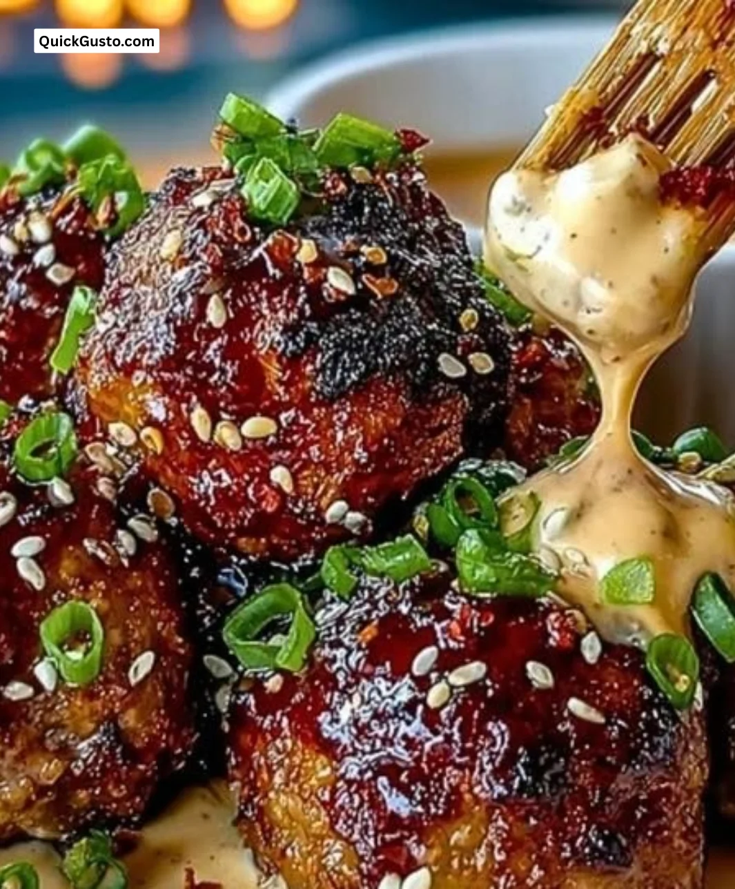 Korean BBQ Meatballs garnished with sesame seeds and served with spicy mayo dip.