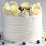 Delicious homemade Lemon Blueberry Cake with frosting and fresh berries