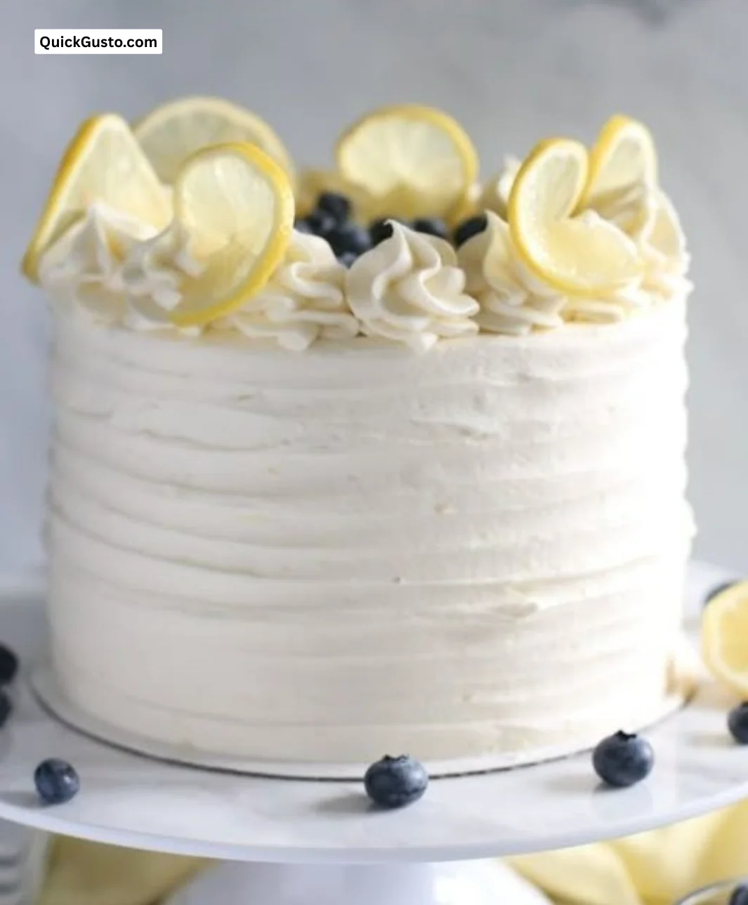Delicious homemade Lemon Blueberry Cake with frosting and fresh berries