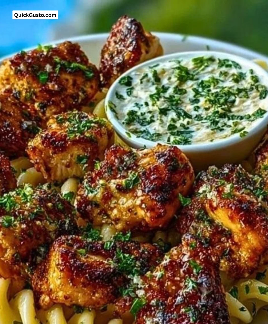 Lemon Cajun Chicken Bites served with creamy garlic herb Alfredo twists on a plate.