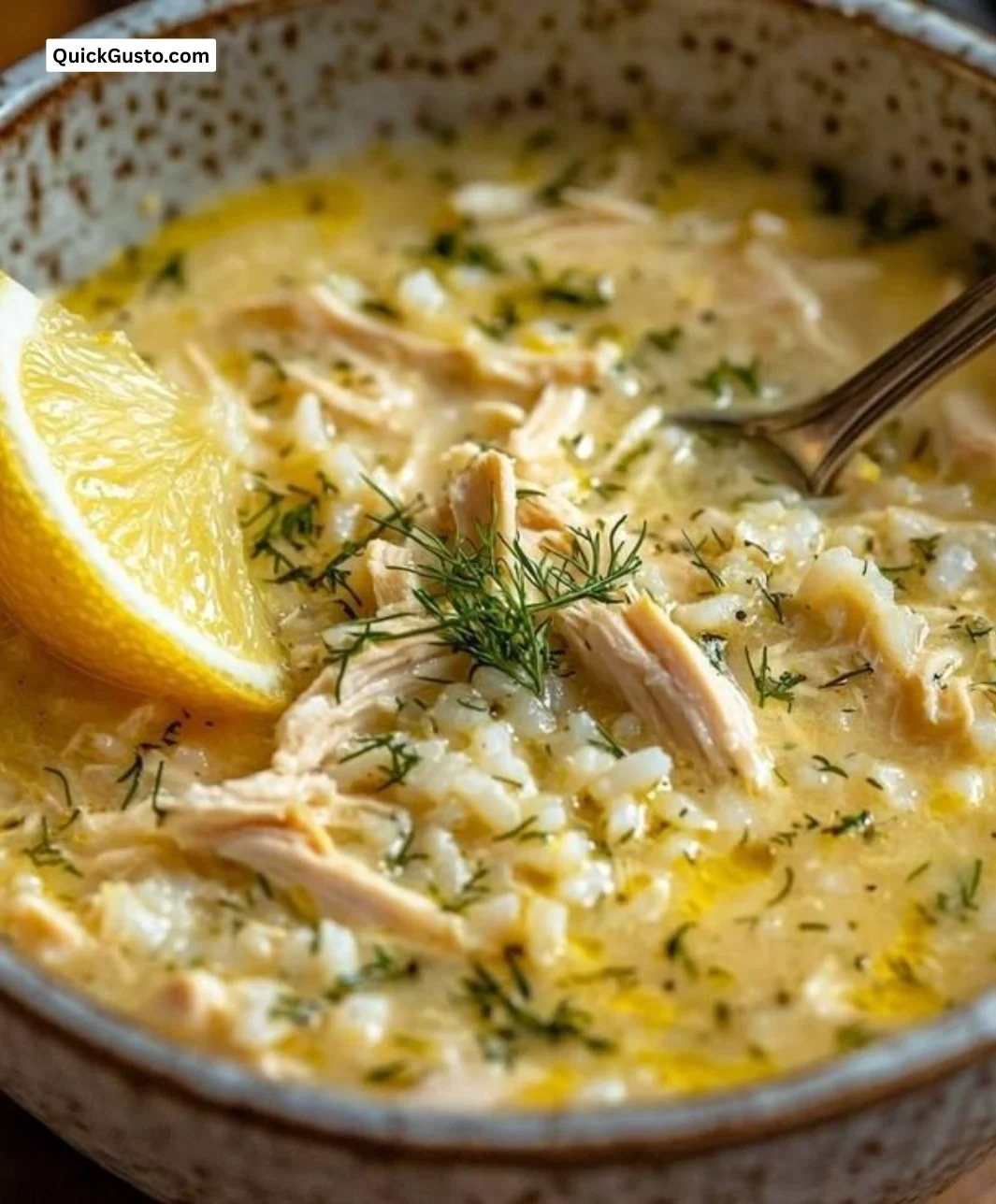 Bowl of Mediterranean Lemon Chicken Soup garnished with fresh herbs.