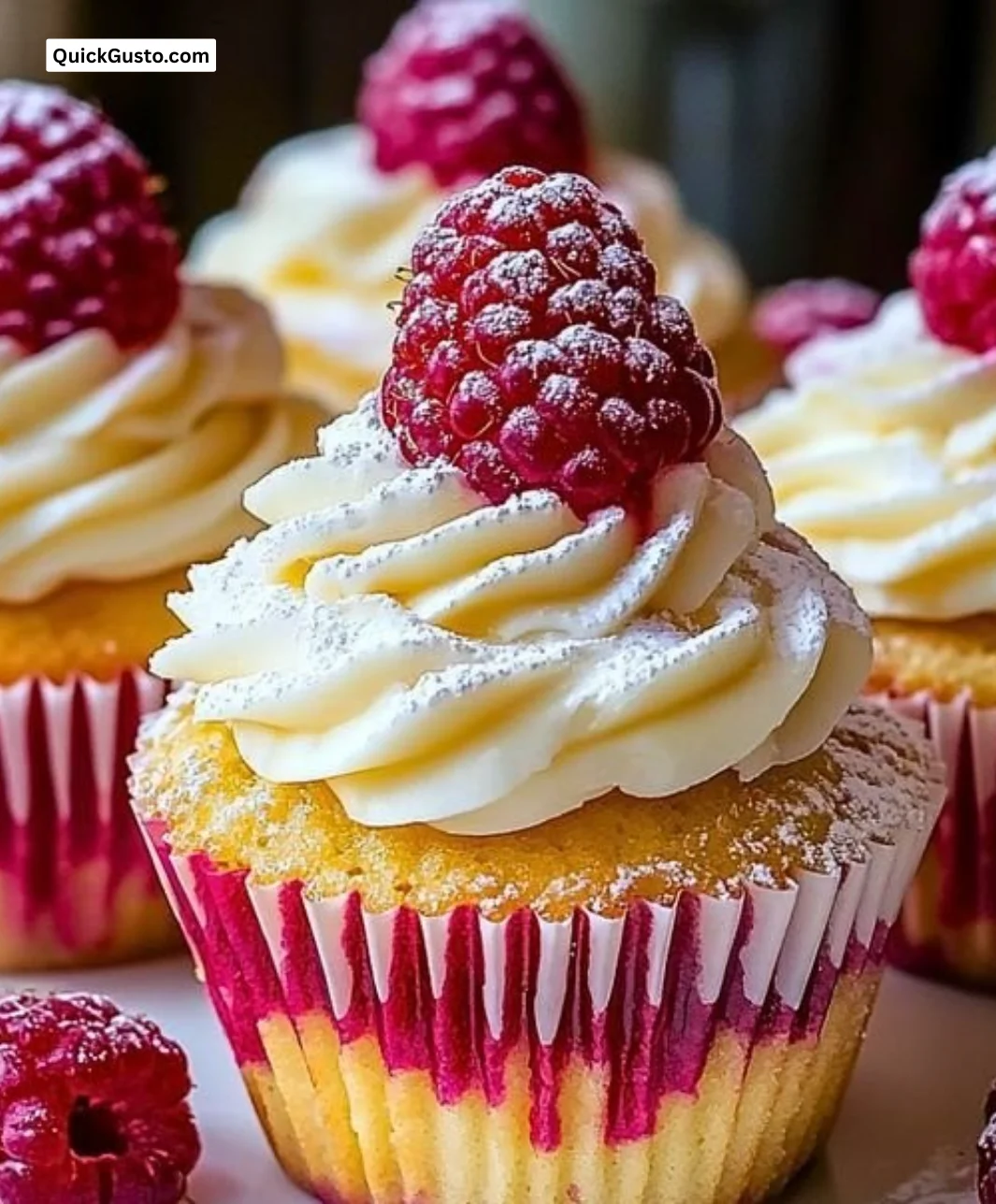 Raspberry Cheesecake Cupcakes topped with fresh raspberries and creamy frosting.