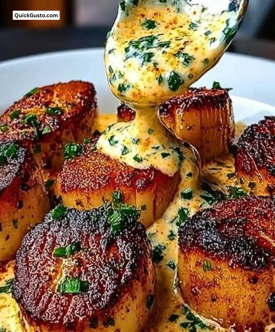 Seared scallops served with spicy Cajun cream sauce on a plate