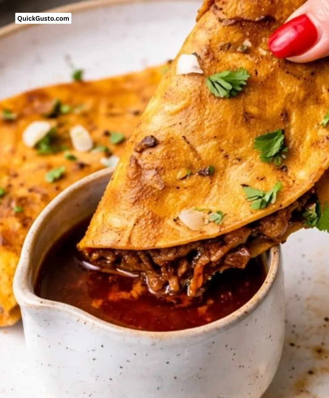 Delicious slow cooker birria tacos served with fresh cilantro and lime.
