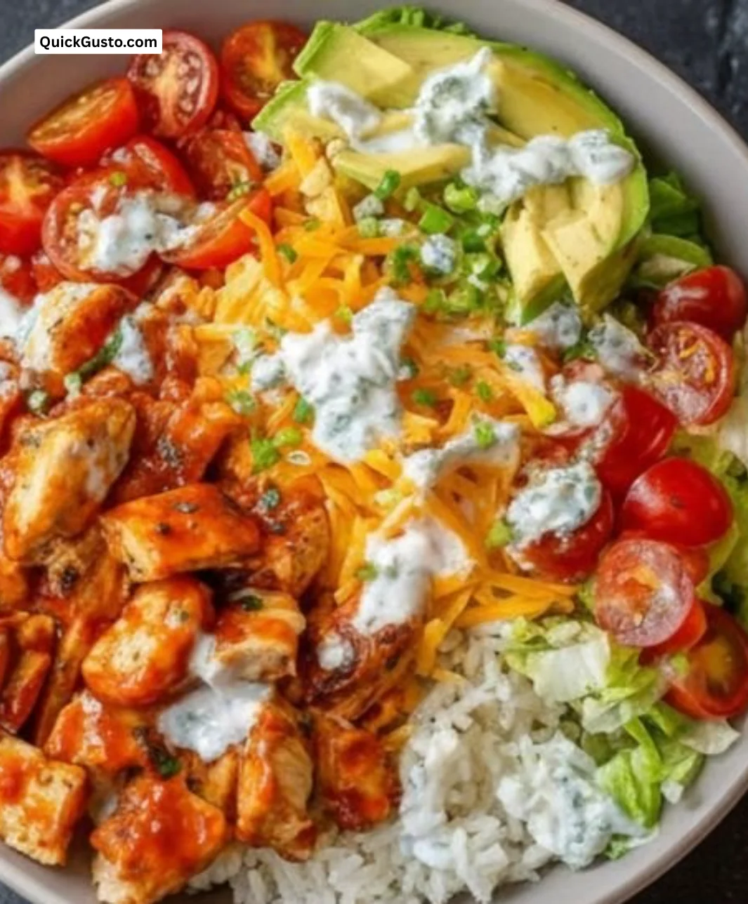 Spicy Buffalo Chicken Rice Bowls topped with green onions and creamy dressing