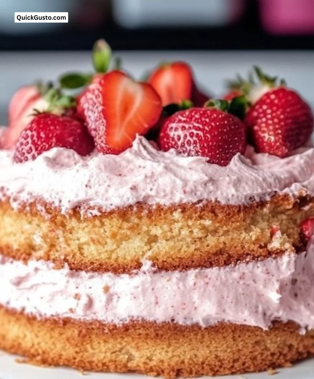Strawberry vanilla sponge cake topped with fresh strawberries and cream