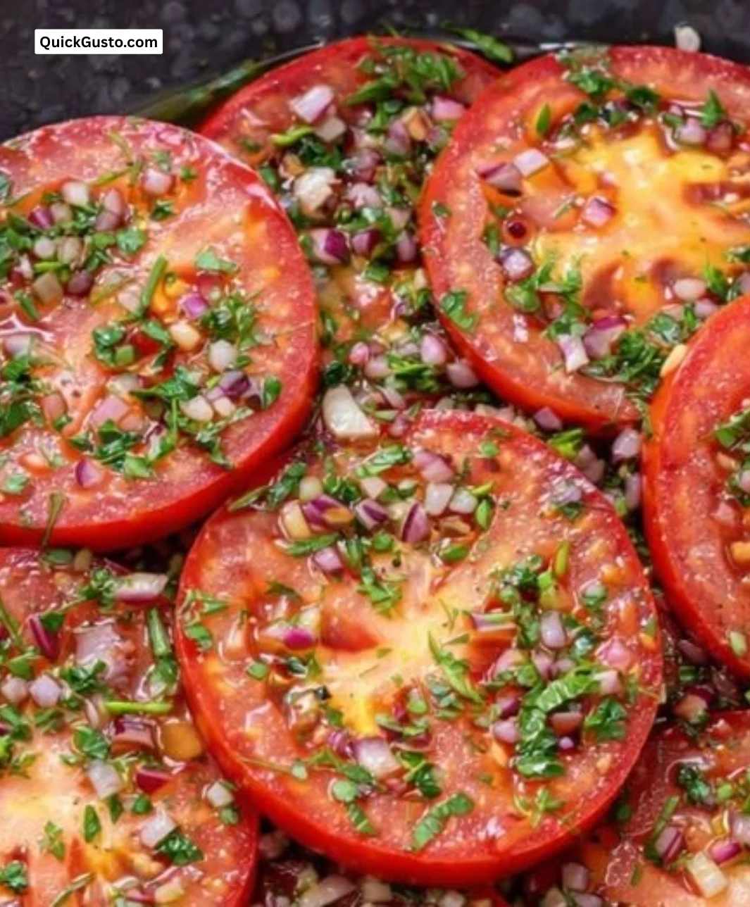 Bowl of sun-kissed marinated sliced tomatoes seasoned with herbs.