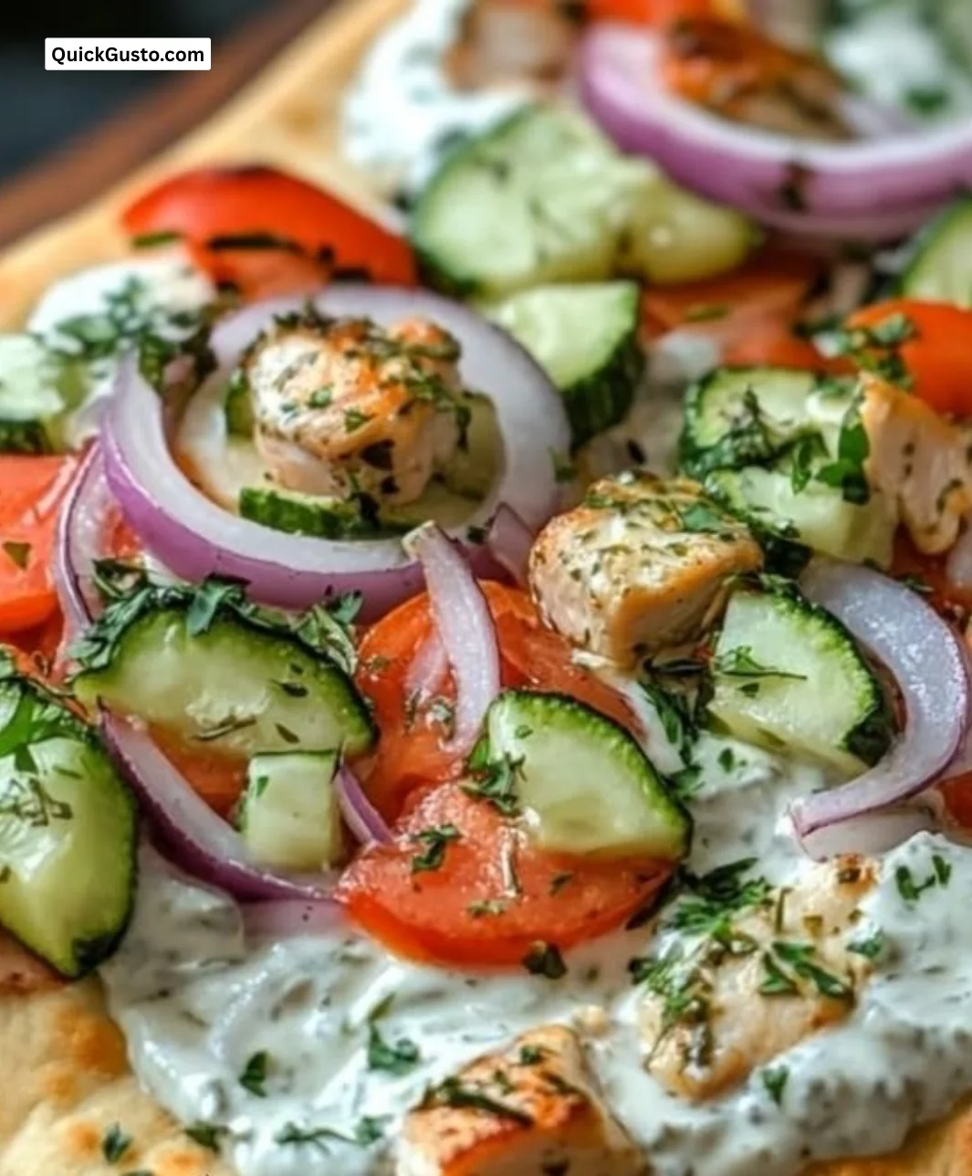 Tzatziki chicken and vegetable naan pizza topped with fresh ingredients.