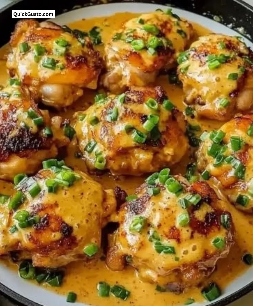 Crispy Bang Bang Chicken thighs served with creamy sauce and garnishes.