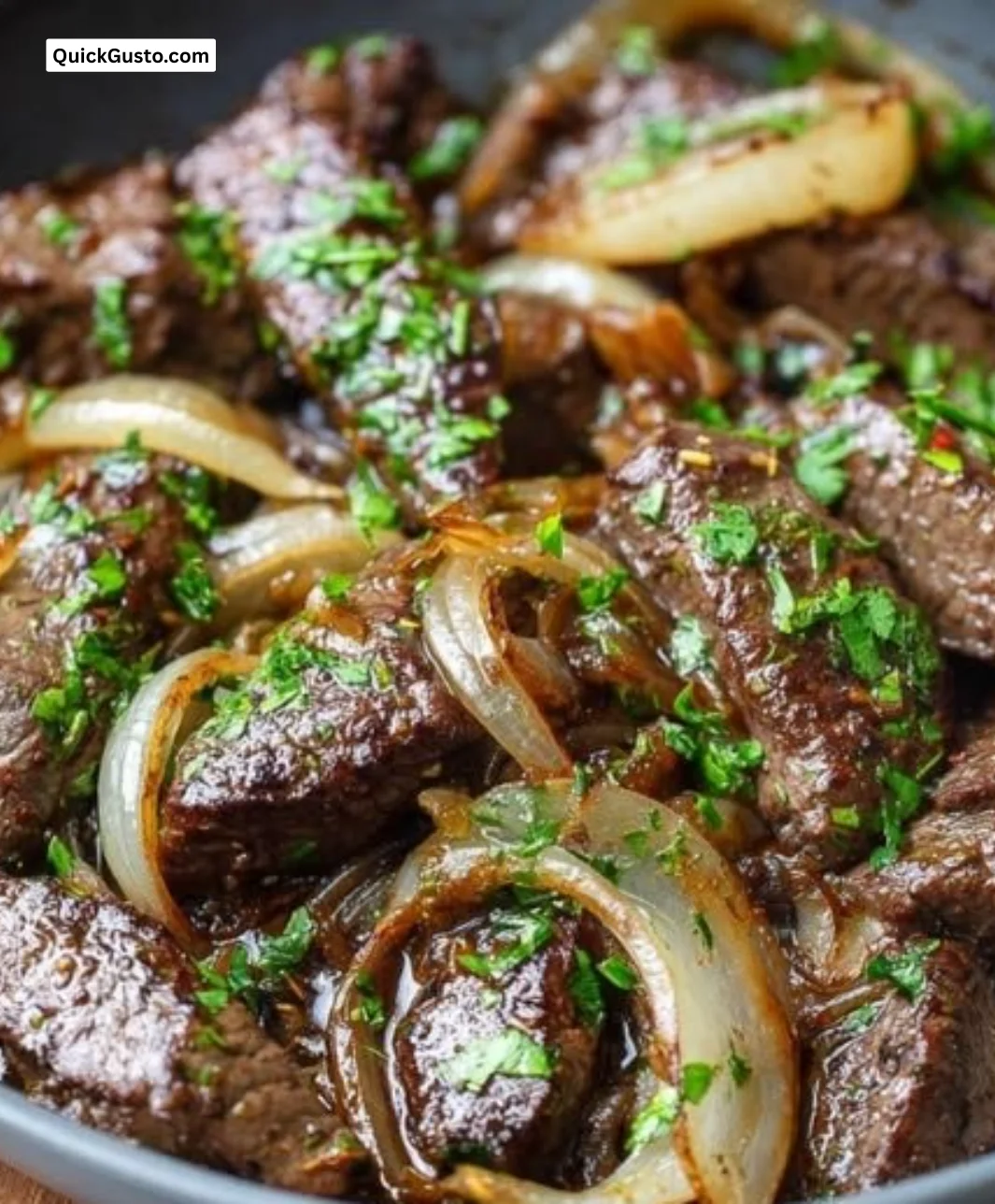 A cozy skillet of beef liver and onions, garnished and ready to serve