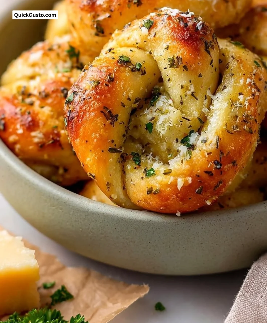 Homemade garlic knots served warm and golden-brown, topped with garlic and herbs.