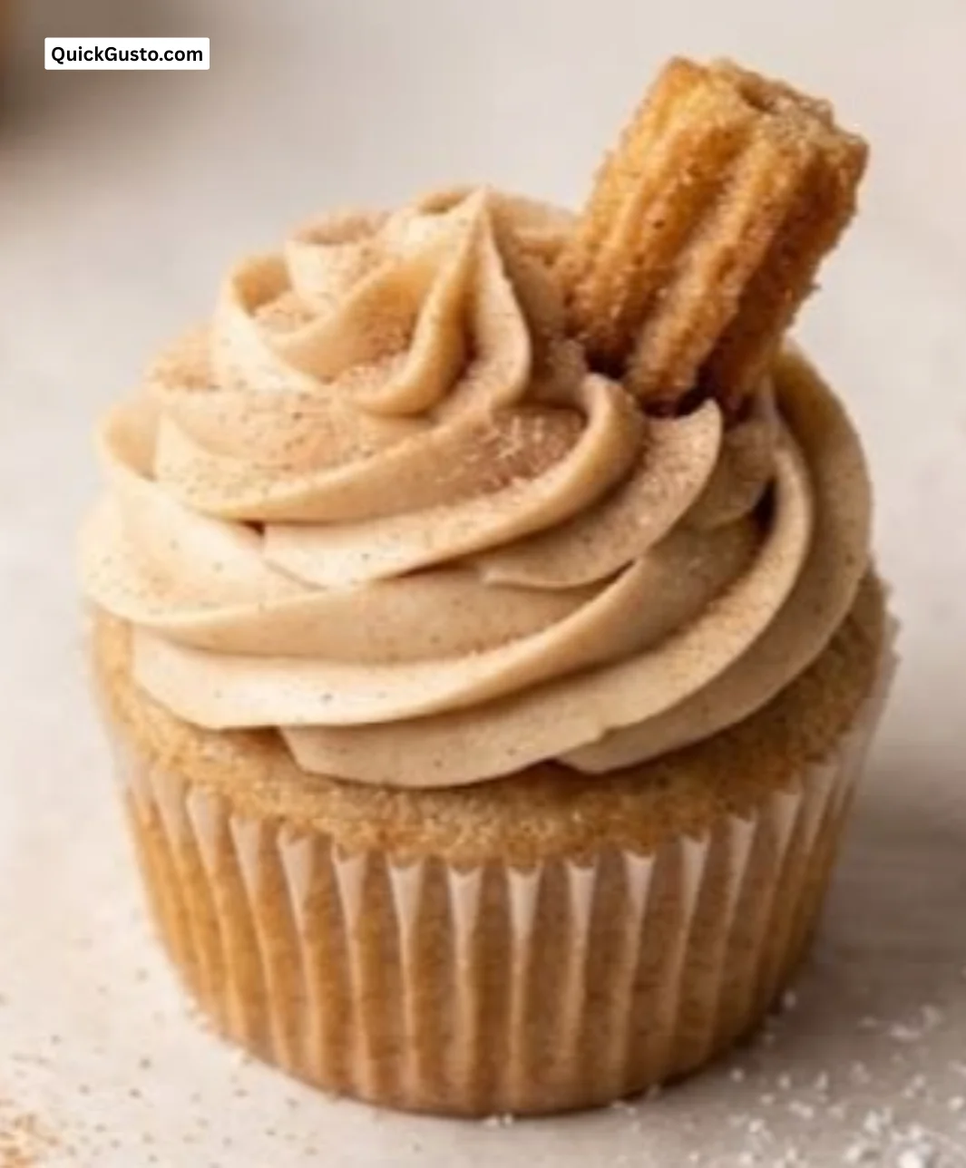 Churro cupcakes topped with cinnamon and sugar, showcasing a delicious dessert treat.