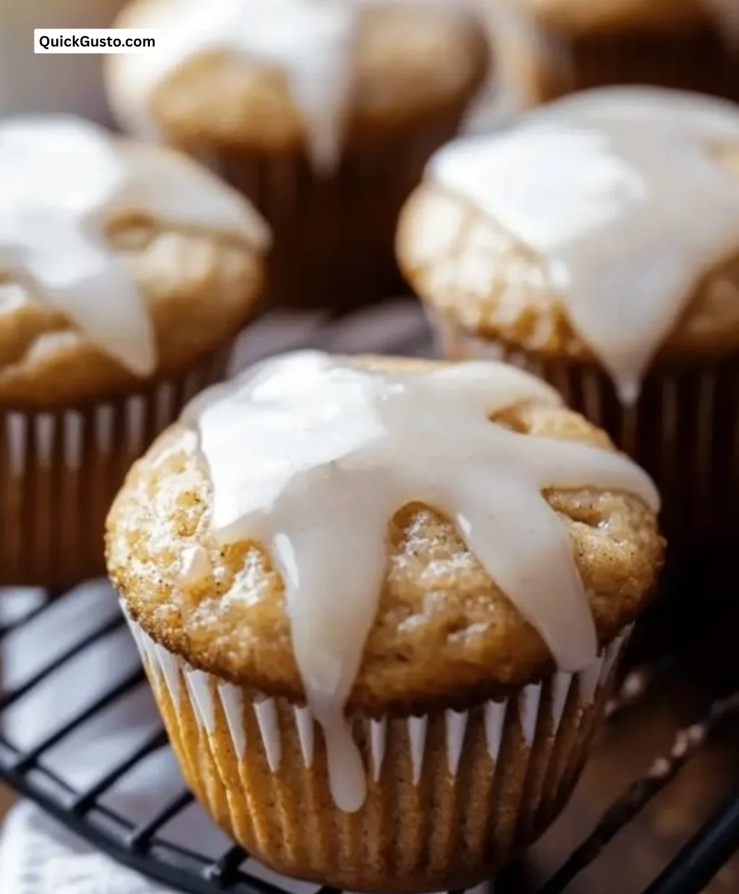 Irresistible chai muffins with vanilla bean glaze on a rustic wooden table.