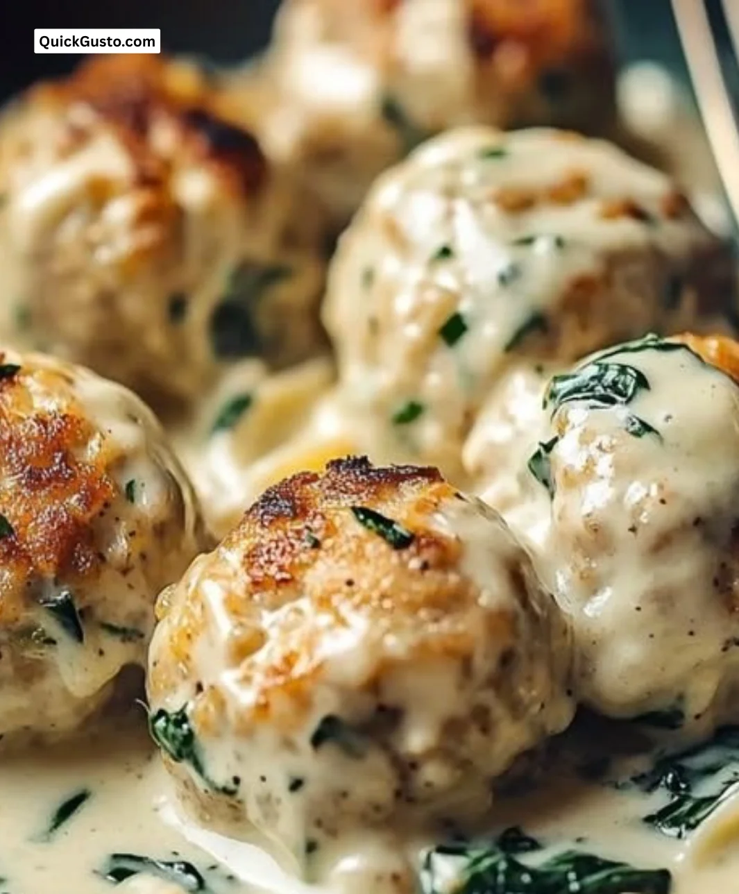 Delicious creamy chicken ricotta meatballs in Alfredo sauce served on a plate.