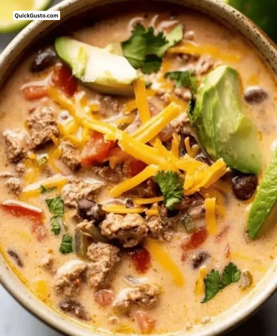 Bowl of creamy taco soup ready in 30 minutes topped with cheese and cilantro