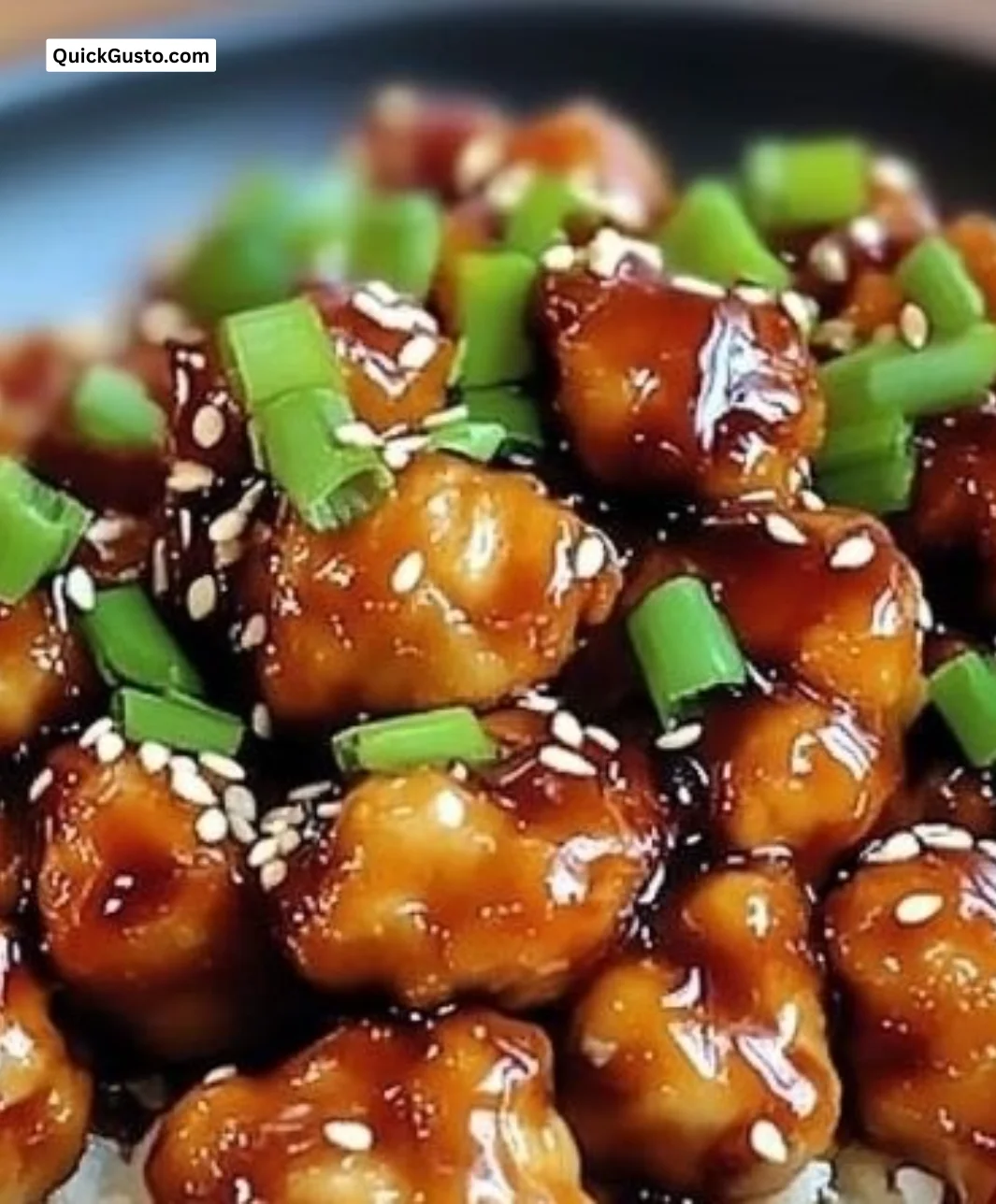 Plate of crispy General Tso's Chicken garnished with vegetables and sauce