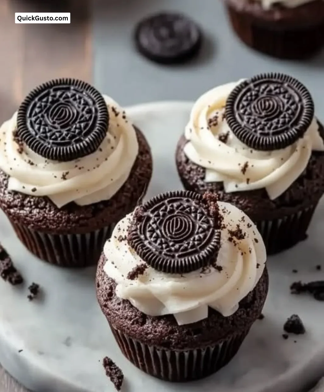 Decadent double chocolate Oreo brownie cupcakes topped with cream and chocolate drizzle.